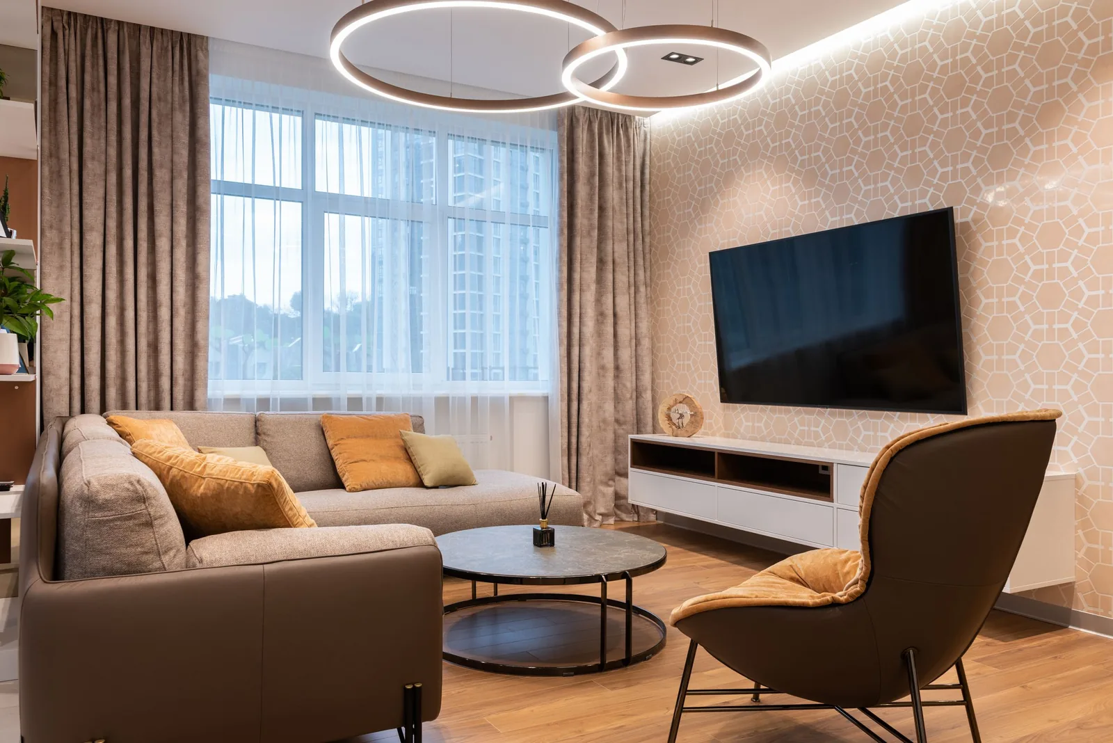 A light-filled living room with a sofa, armchair and round coffee table.